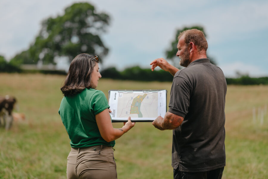Farmer and advisor look at land map in a field
